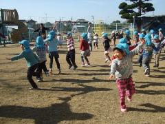 写真：芝生の上で子ども達が体操をしている