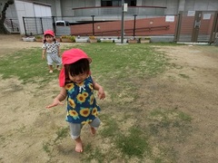 1歳児が芝の上を裸足で歩いている写真