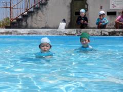交流活動で小学校に行って小学校のプールで遊んでいる年長児の写真
