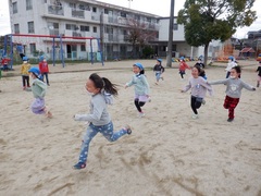 小学校の校庭で遊ぶ幼児の写真