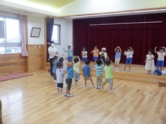 ホールで盆踊りを踊る幼児の写真