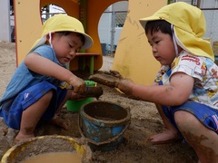 泥で遊ぶ幼児の写真