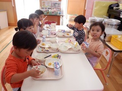 給食を食べる幼児の写真