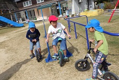 小学生と一緒に一輪車に乗る幼児とマウンテンバイクに乗る幼児