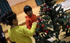 クリスマスツリーを飾る幼児