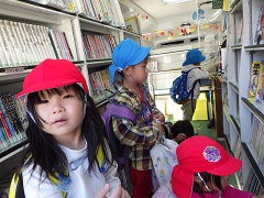 移動図書館で本を見る幼児