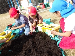 植木鉢に土を入れる幼児たち