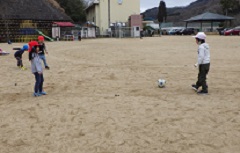 小学生と一緒にサッカーをする幼児