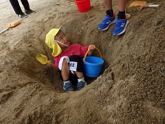 砂の穴に入る幼児