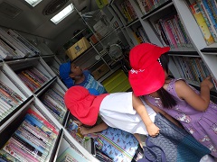 移動図書館で絵本を選ぶ幼児