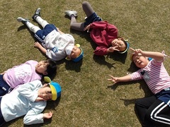 芝生で寝転ぶ子どもたち