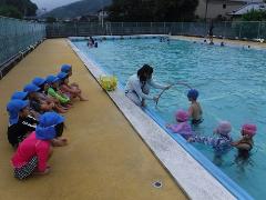 小学校のプールを見学する幼児