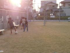 写真：夕日を背にサッカーを楽しむ子供たちの様子