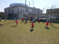 写真：グラウンドで園児たちがサッカーをする様子