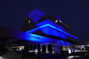 松山市総合福祉センターが青色にライトアップされている写真です。