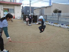 芝生の上で長縄跳びをしている写真