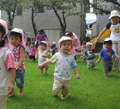 芝生に踏み入る0・1歳児の子どもたち