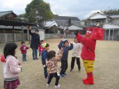 芝生の上で鬼とダンスをする子どもたち