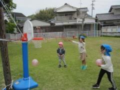 芝生の上でバスケット遊びを楽しむ子どもたち