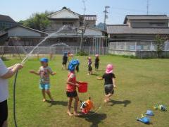 芝生の上で水浴びをする子どもたち