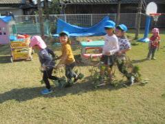 芝生の上で電車ごっこをする子どもたち