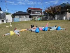 芝生の上で寝ころんでいる子どもの写真