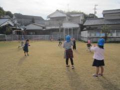 芝生の上でしゃぼん玉遊びをする子どもたち