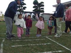 写真：子ども達が芝生の上で交通安全教室に参加をしている