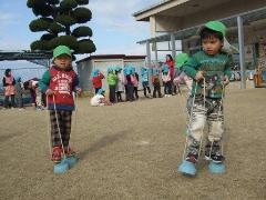 写真：缶ぽっくりで遊んでいる2歳児