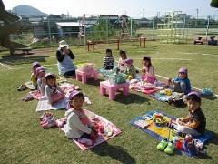 芝生の上でお弁当を食べる子どもたち