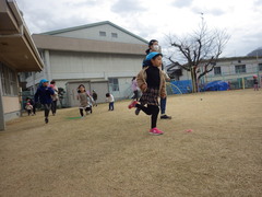 芝生の上でマラソンをする子どもたち