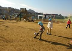 園庭でこどもがサッカーをしている写真