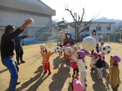 園庭でボール遊びを楽しんでいる写真