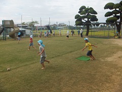 子どもたちが芝生の上で走っている写真