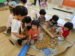 2歳児が木の玩具で遊んでいるところ