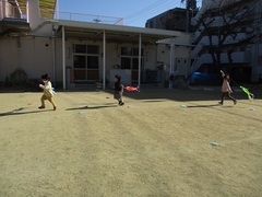 芝の上で3歳児が凧あげをしている写真