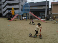 芝生の上を2歳児がスケーターで走っている写真