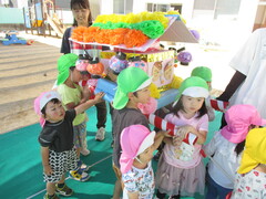 異年齢児が一緒にお祭りごっこをしている様子