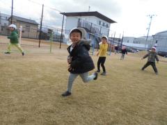 芝生で追いかけっこをしている3歳児の写真