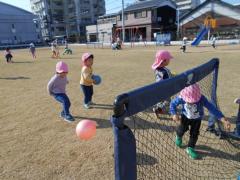 芝生の上でサッカーをしている2歳児の写真