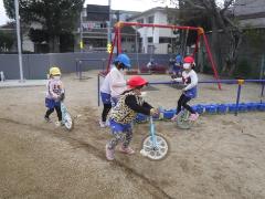 3、4、5歳児が一緒に一輪車をしている様子