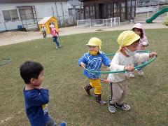 園庭で電車ごっこをして遊んでいる様子