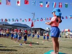 運動会の開会式の歌で指揮者をする幼児の写真