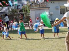 ポンポンを持って運動会の踊りを楽しんでいる幼児の写真