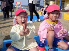 焼き芋パーティーで焼き芋を食べる幼児の写真