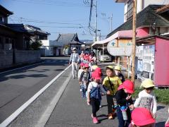 園外保育で公園まで歩く幼児の写真