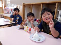 誕生会のおやつのケーキを食べている幼児の写真