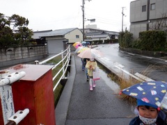 傘を差して歩いている写真