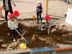 砂場で遊んでいる幼児の写真