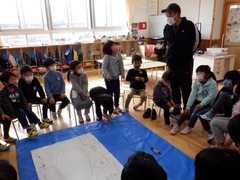 幼稚園の園舎の図を書いて話し合いをしている年長児の写真